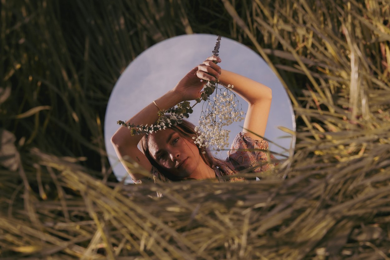 Young Woman with Flowers Reflected on Mirror